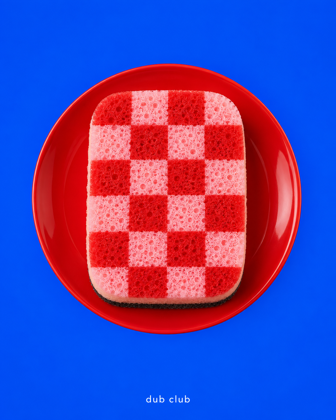 Red and pink checker sponge on a cherry-red plate against cobalt blue